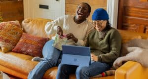 a person sitting on a couch with a laptop